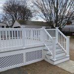 White wooden deck with stairs leading to a backyard, exemplifying XTEND Contracting’s skill in deck and porch construction.