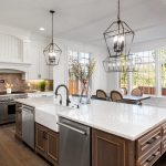 Spacious modern kitchen with a marble island, dark wooden cabinetry, and stylish pendant lights, showcasing XTEND Contracting’s expertise in kitchen remodeling